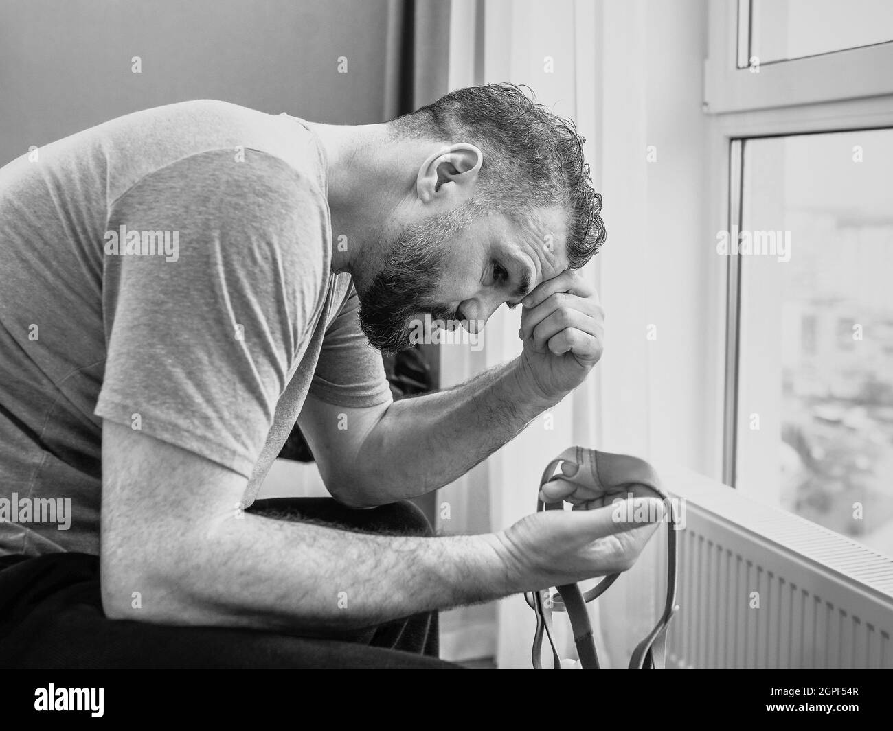 Unglücklich schockiert Mann mit chronischen Atemproblemen überrascht, indem CPAP-Maschine auf dem Bett im Schlafzimmer sitzen. Stockfoto