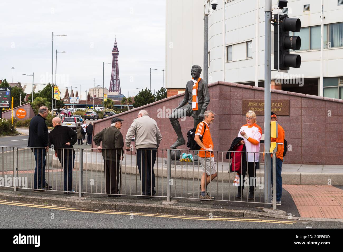 Blackpool FC Fans versammeln sich an einem Spieltag neben der Jimmy Armfield Statue in der Bloomfield Road mit dem Blackpool Tower in der Ferne. Gesehen im September Stockfoto