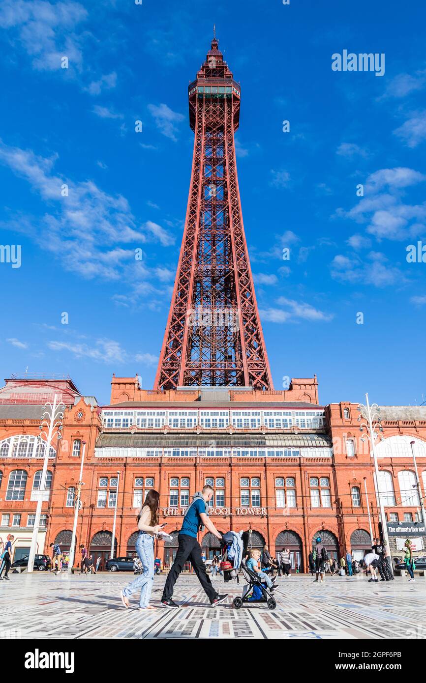 Eine junge Familie sah im September 2021 auf dem Comedy-Teppich am Blackpool Tower vorbeilaufen. Stockfoto