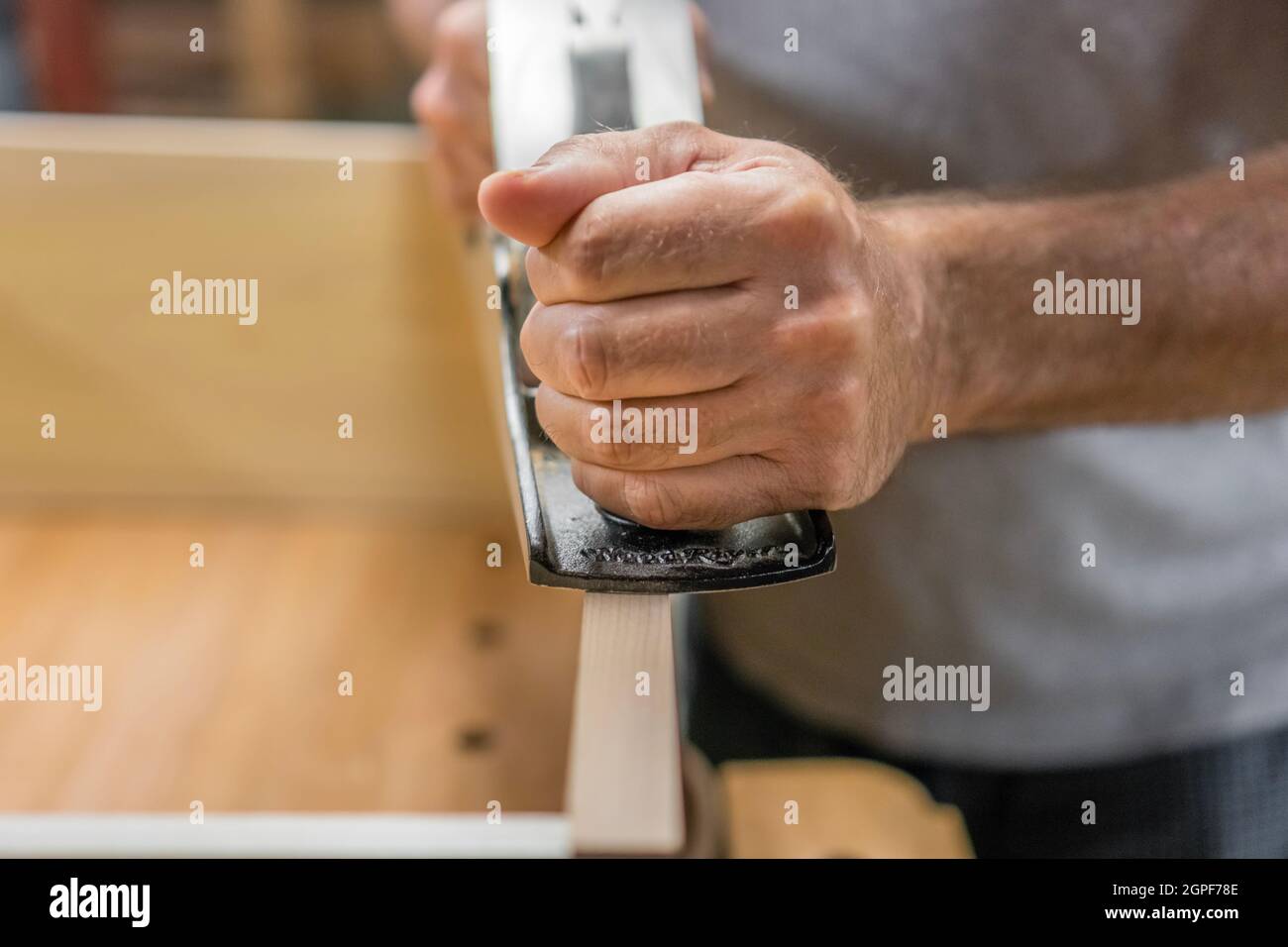 Mann Holzbearbeitung mit Hand Flugzeug Werkzeug. Stockfoto