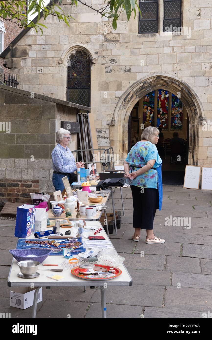 Leute, die Geld sammeln mit einem Kirchhof Verkauf von Bric a brac Second Hand Waren, York England Großbritannien Stockfoto