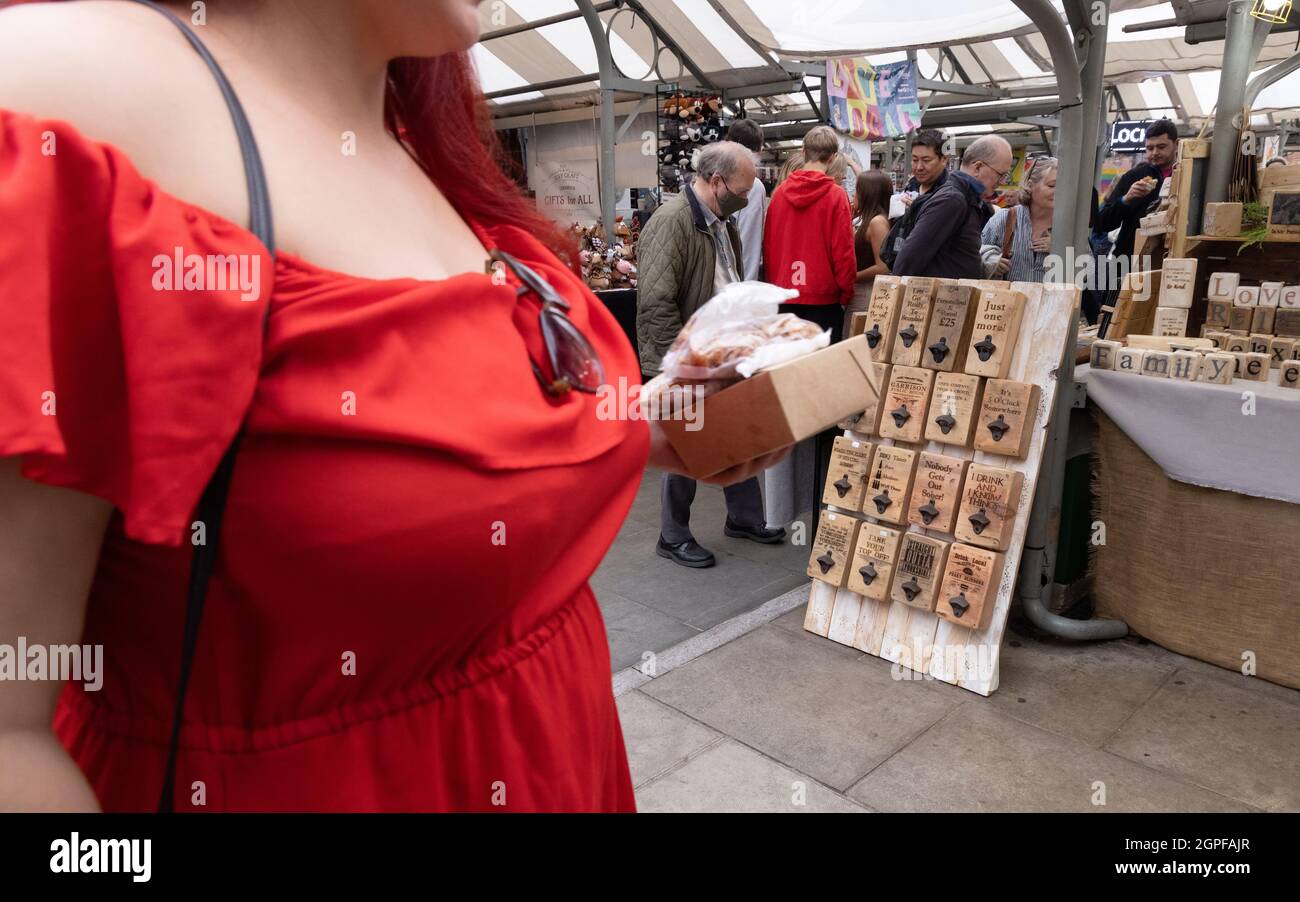 Frau, rotes Kleid; Frau, die auf dem Shambles-Markt, York, Yorkshire, Großbritannien, einkauft Stockfoto