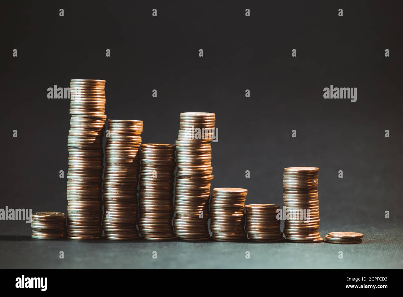 Ungleichmäßige Grafik in Form von Goldmünzen auf dunklem Hintergrund. Stockfoto