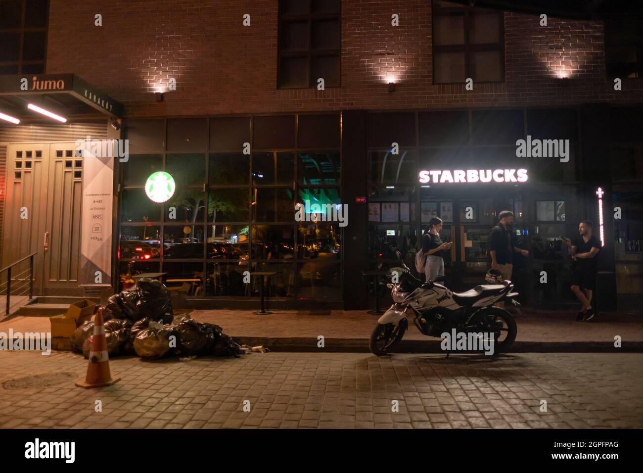 Beyoglu, Istanbul, Türkei - 07.07.2021: Mitarbeiter von Starbucks in der Region Karakoy schließen das Café nachts und gehen nach Hause für ein berühmtes Restaurant Stockfoto