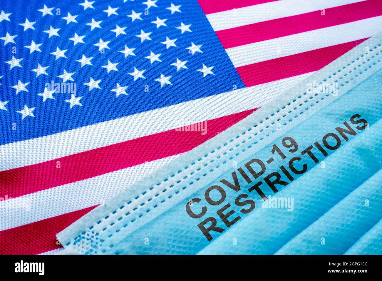 USA Flagge und Gesichtsmaske mit covid 19 Einschränkungen Zeichen. Stockfoto