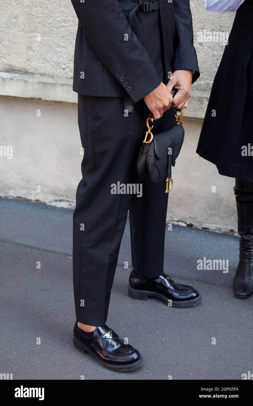 MAILAND, ITALIEN - 24. SEPTEMBER 2021: Mann mit schwarzer Ledertasche Dior und Prada-Schuhen vor der Prada-Modenschau, Mailand Fashion Week Street Style Stockfoto