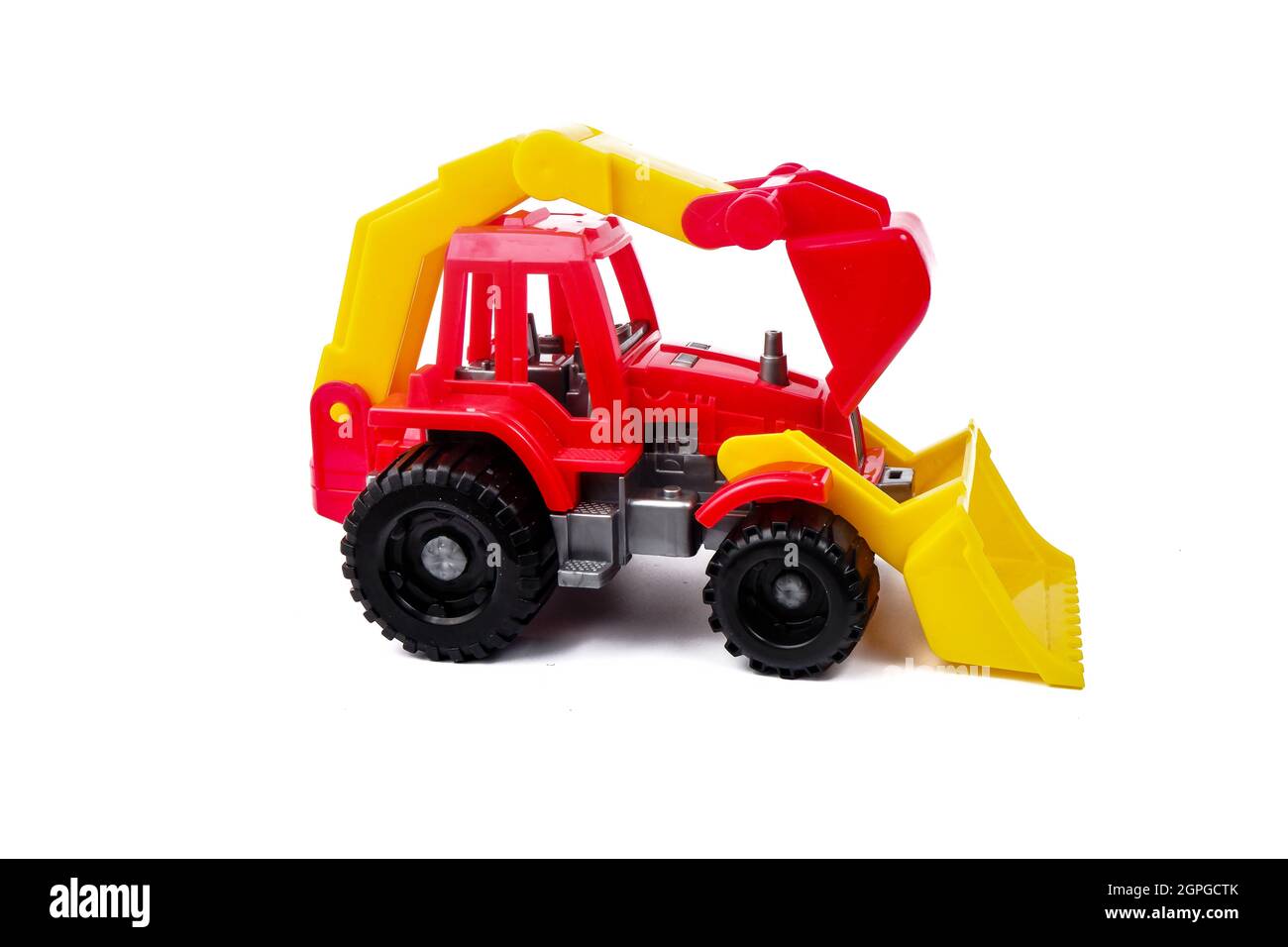 Kinderspielzeug aus rotem Kunststoff Traktor isoliert auf weißem Hintergrund Stockfoto