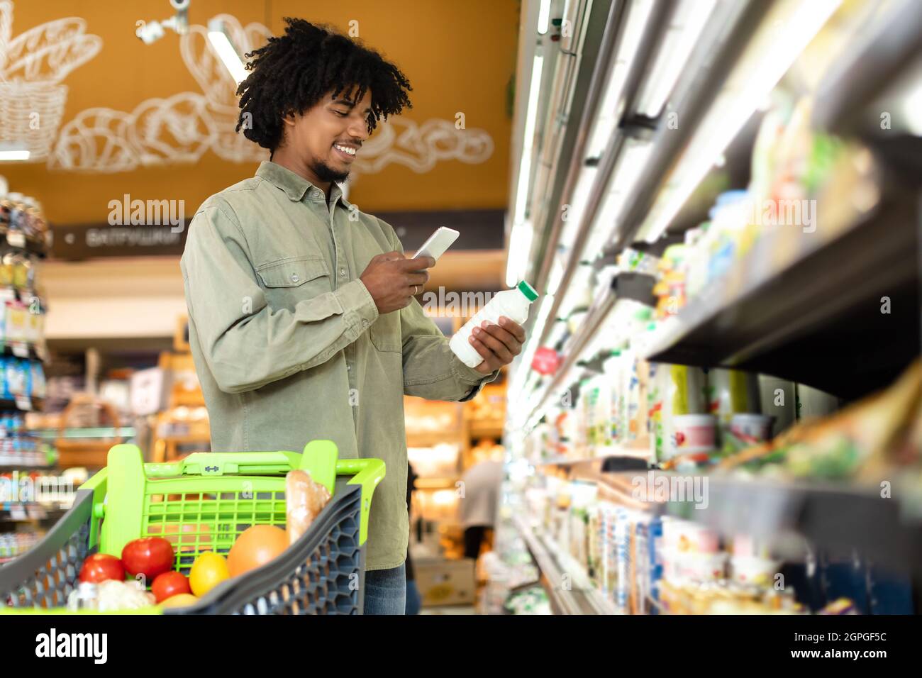 Black Guy Milch Scannen Mit Smartphone Lebensmittel Im Supermarkt Kaufen Stockfoto
