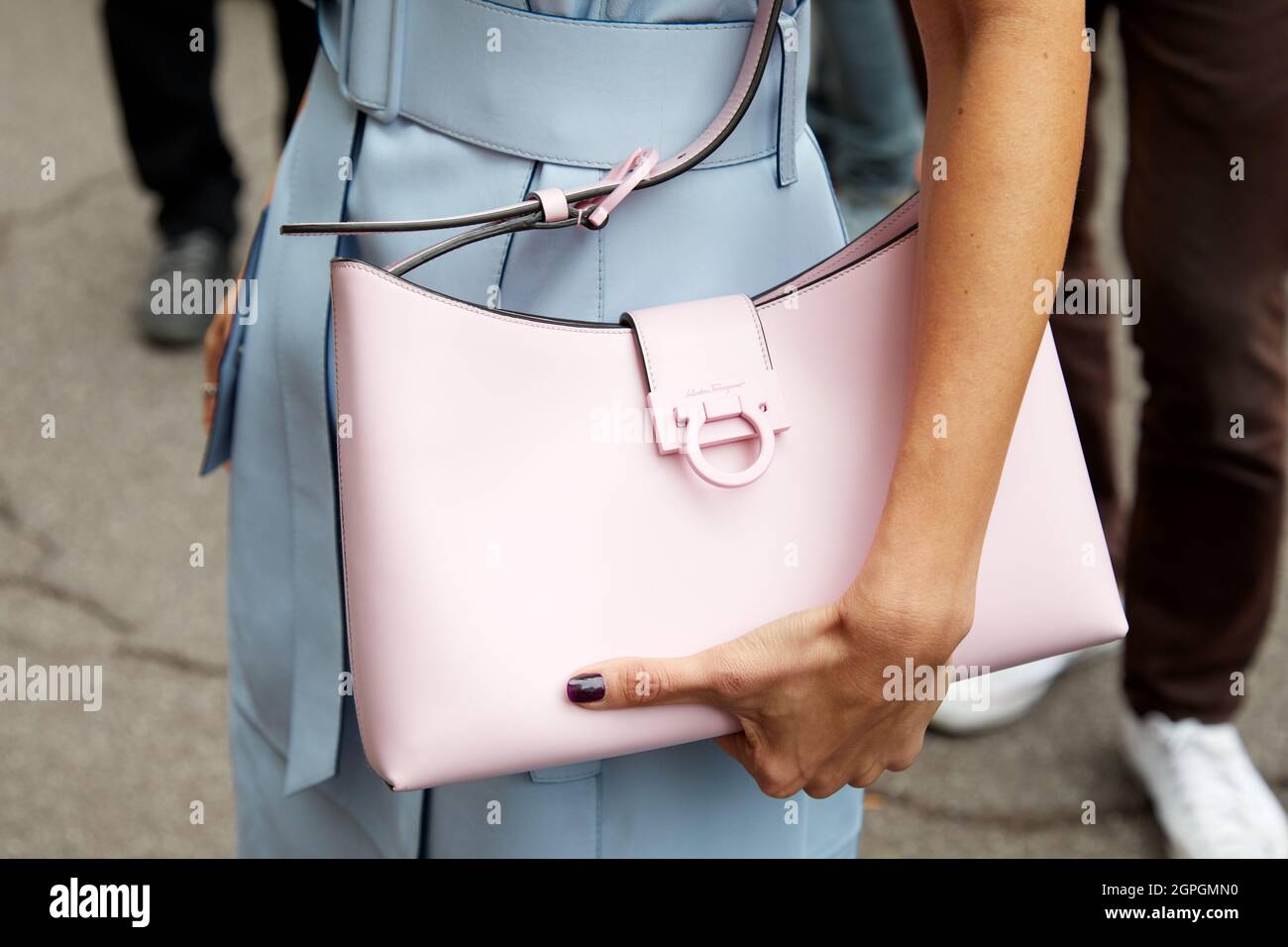 MAILAND, ITALIEN - 25. SEPTEMBER 2021: Alexandra Pereira mit einem ärmellosen Kleid aus hellblauem Leder und einer rosa Ferragamo-Tasche vor Salvatore Ferragamo Stockfoto