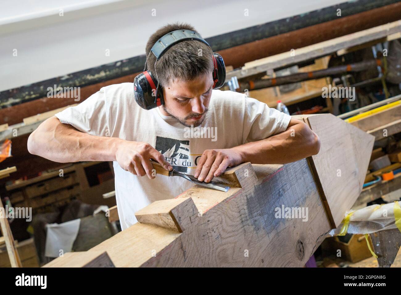 Frankreich, Finistere, Brest, Guip Shipyard, ein mariner Zimmermann arbeitet mit einem Holzmeißel Stockfoto