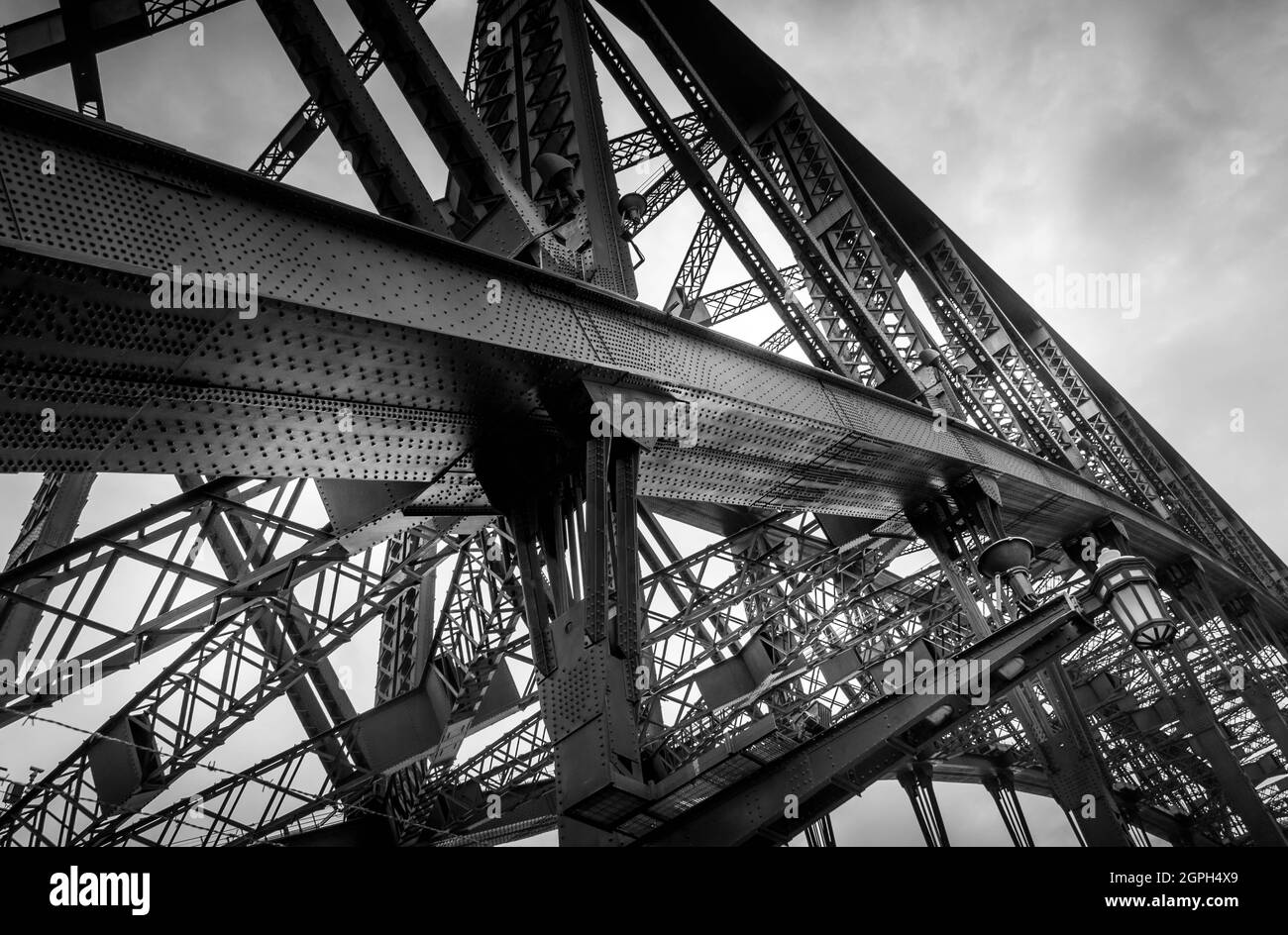 Schwarz-weißes Bild mit Details auf der Hafenbrücke von Sydney, das Struktur mit Nieten zeigt. Keine Personen. Stockfoto