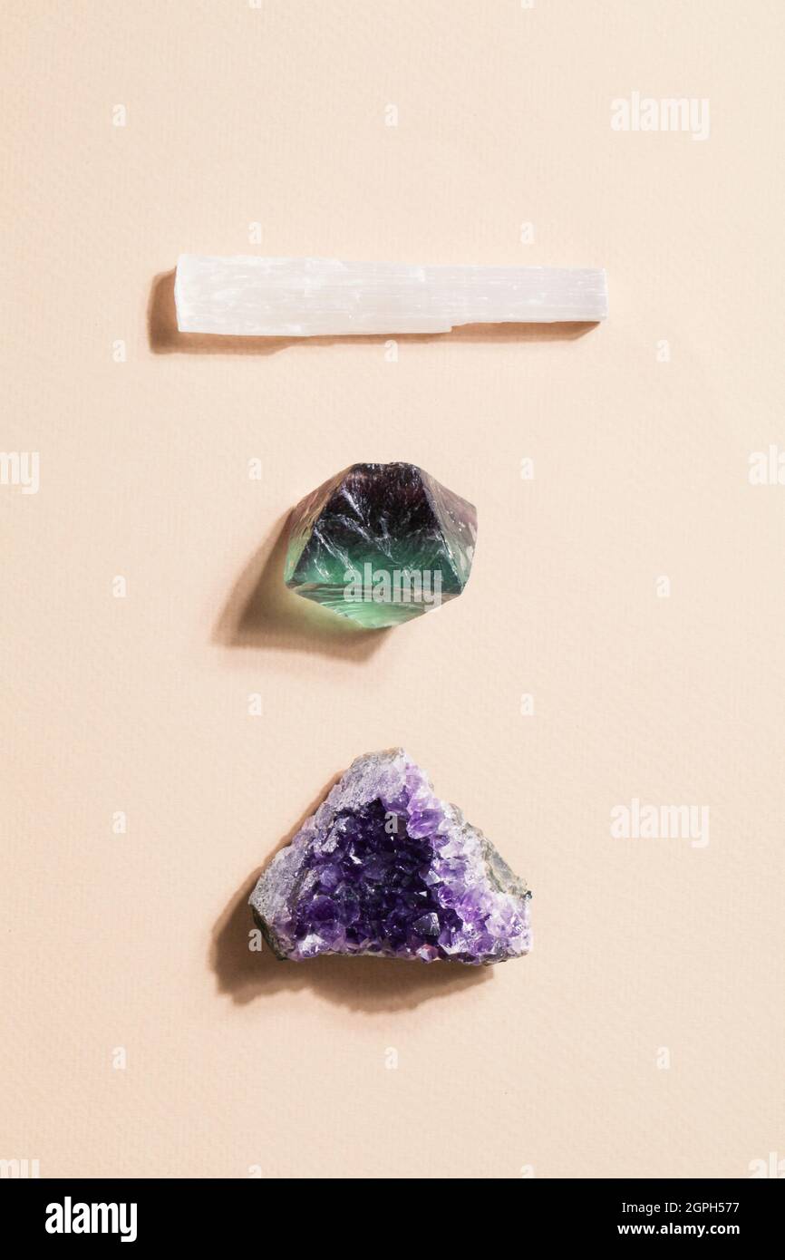 druse roher purpurner Amethyst-Kristall, Selenit und Fluorit auf beigem Hintergrund, magischer Fels für Ritual, Hexerei, spirituelle Praxis, Meditation Stockfoto