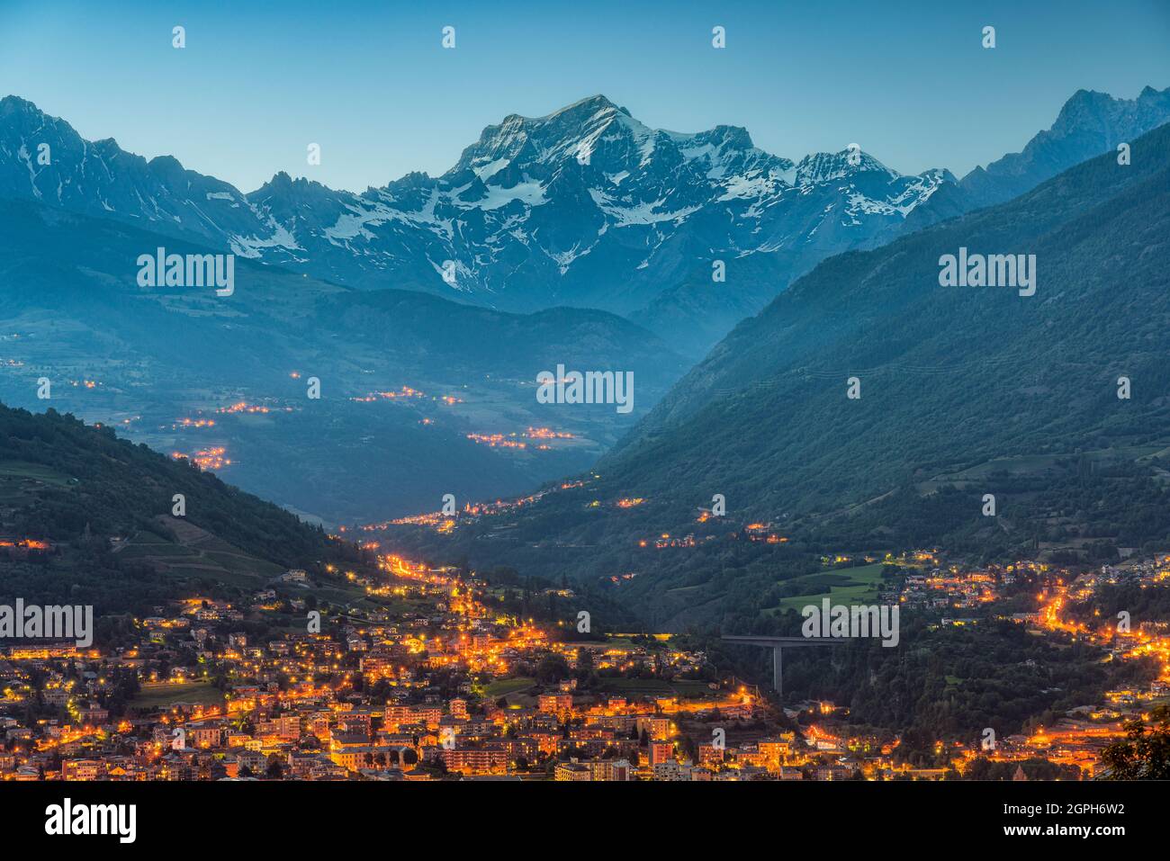 Panorama-Nachtansicht von Aosta beleuchtet mit dem Grand Combin Berg im Hintergrund. Aostatal, Norditalien. Stockfoto