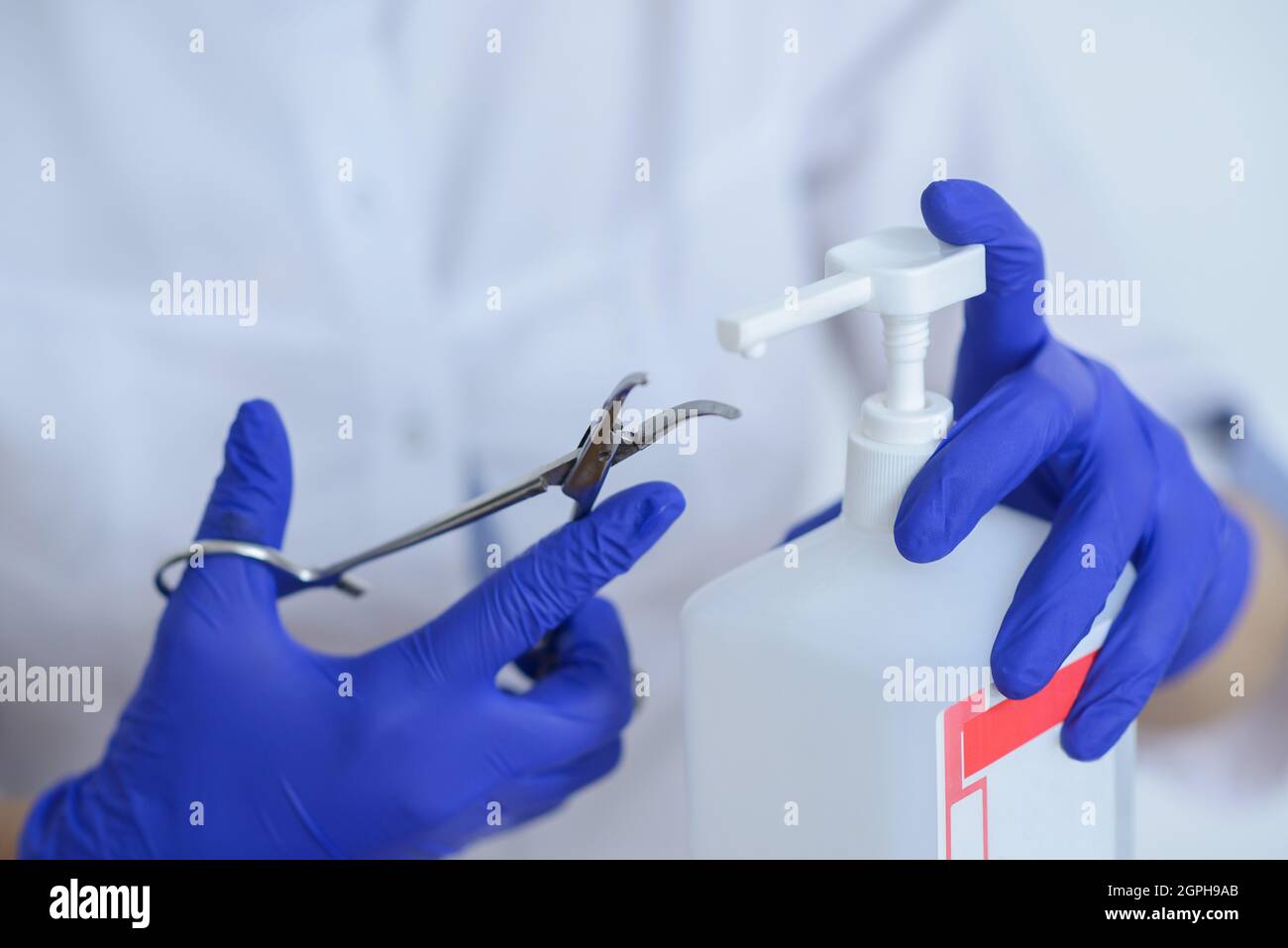 Der Arzt in Latexhandschuhen desinfiziert das medizinische Instrument Stockfoto