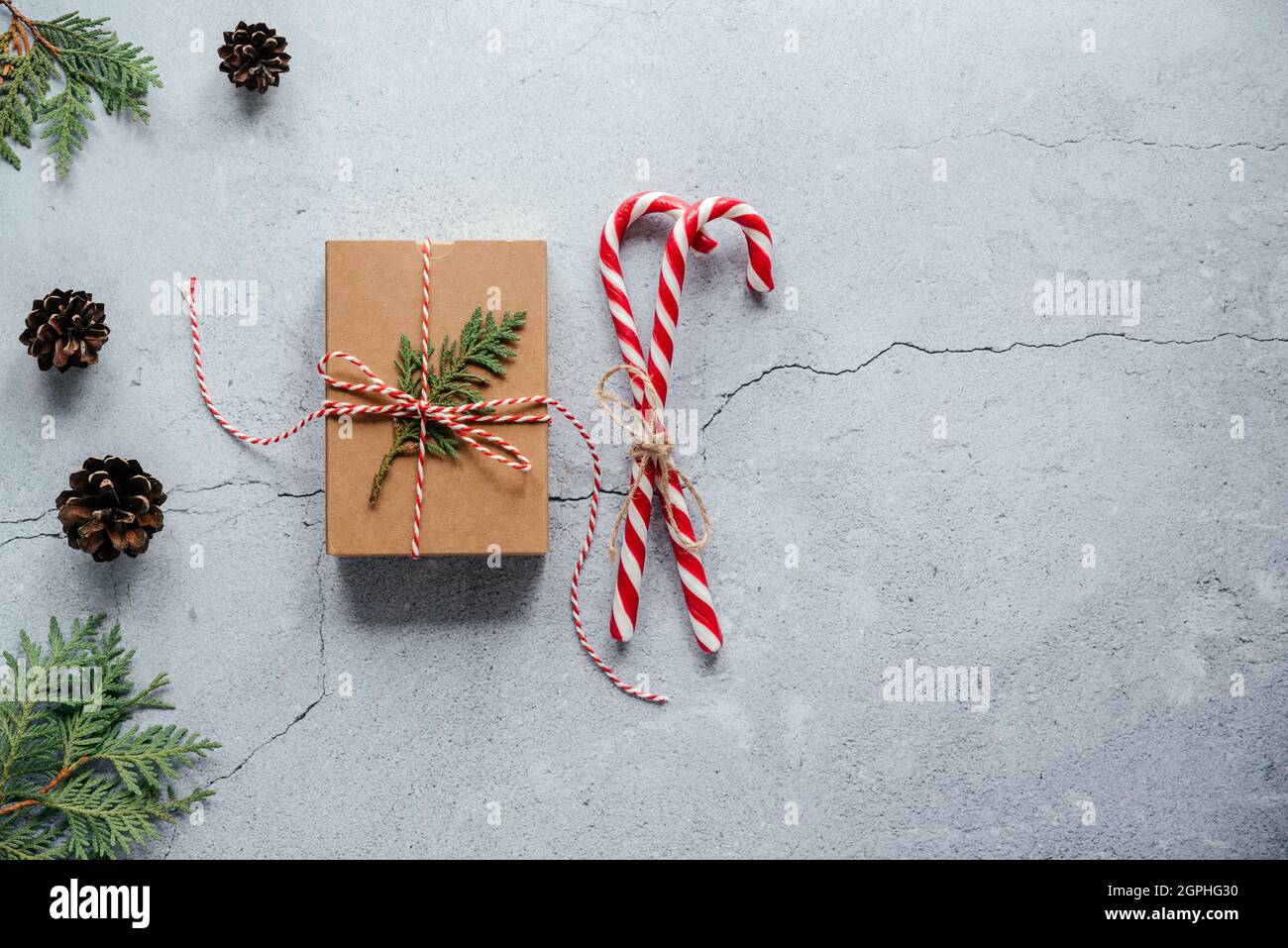 Weihnachts-Geschenkbox mit Thuja-Zweig und Zuckerstöcken verziert Stockfoto