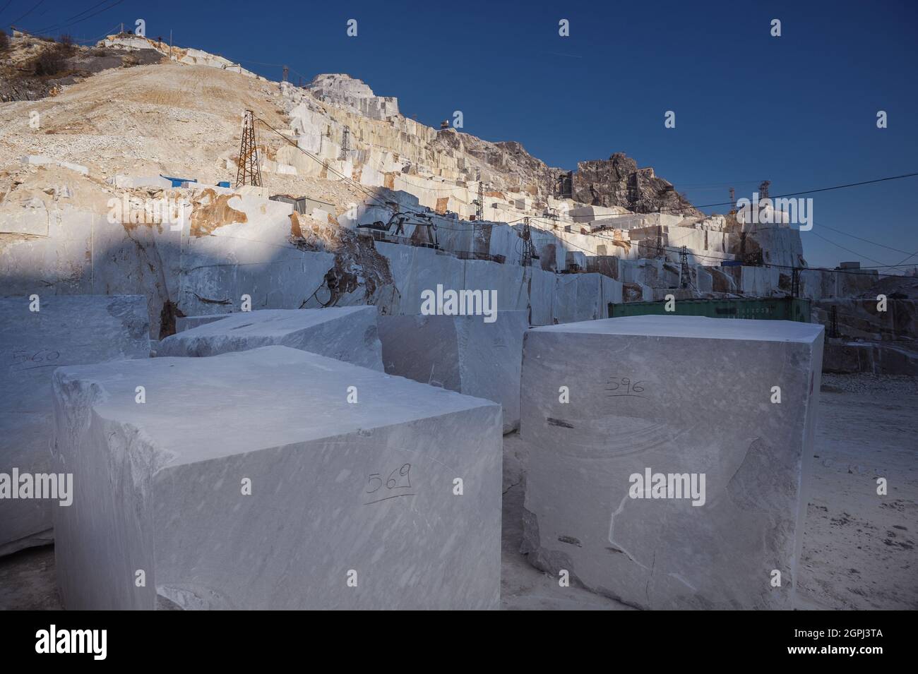 Carrara-Marmorbrüche, viereckige weiße Marmorblöcke auf dem Steinbruch von Gioia, Bulldozer, Maschinen, Bagger, Massa-Carrara, Lunigiana, Toskana, Italien Stockfoto