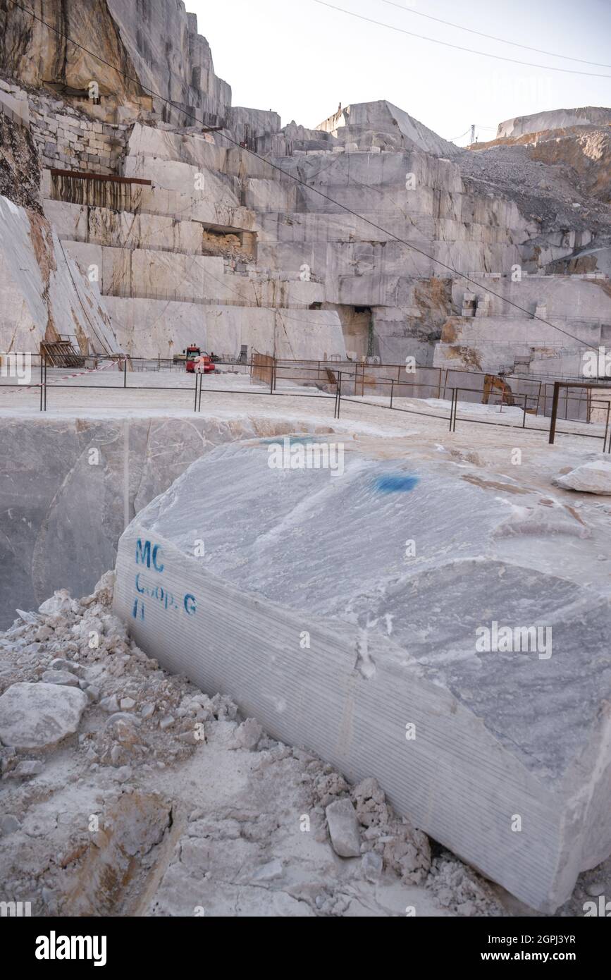 Carrara-Marmorbrüche, viereckige weiße Marmorblöcke auf dem Steinbruch von Gioia, Bulldozer, Maschinen, Bagger, Massa-Carrara, Lunigiana, Toskana, Italien Stockfoto