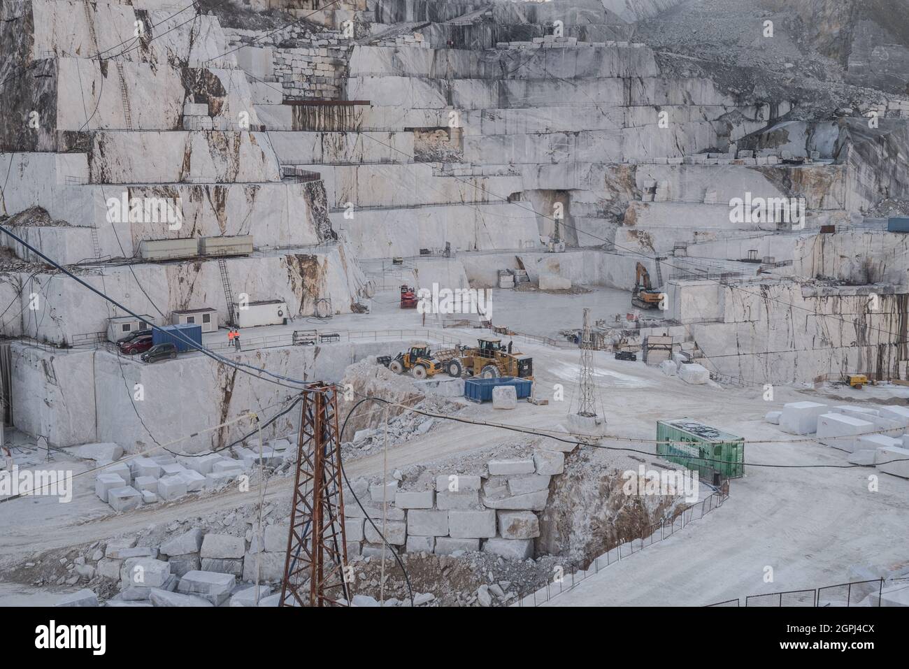 Carrara-Marmorbrüche, viereckige weiße Marmorblöcke auf dem Steinbruch von Gioia, Bulldozer, Maschinen, Bagger, Massa-Carrara, Lunigiana, Toskana, Italien Stockfoto
