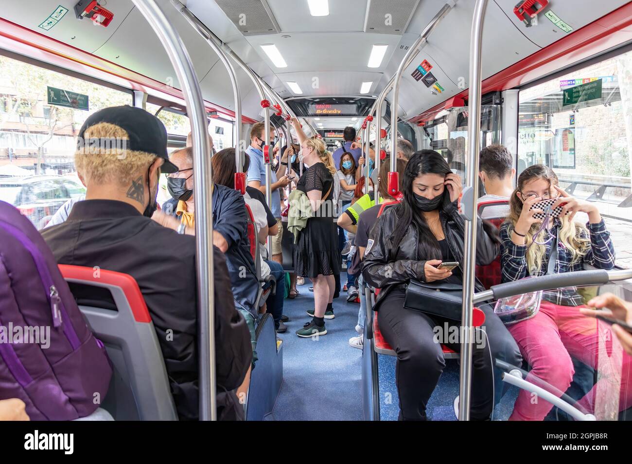 Barcelona, Spanien - 24. September 2021: Menschenmassen in einem Bus. Innenansicht eines Stadtbusses mit Passagieren, die Schutzmaske und Dif Stockfoto