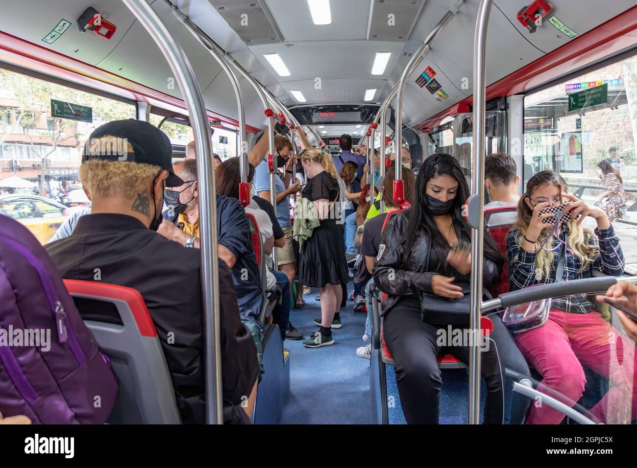 Barcelona, Spanien - 24. September 2021: Menschenmassen in einem Bus. Innenansicht eines Stadtbusses mit Passagieren, die Schutzmaske und Dif Stockfoto