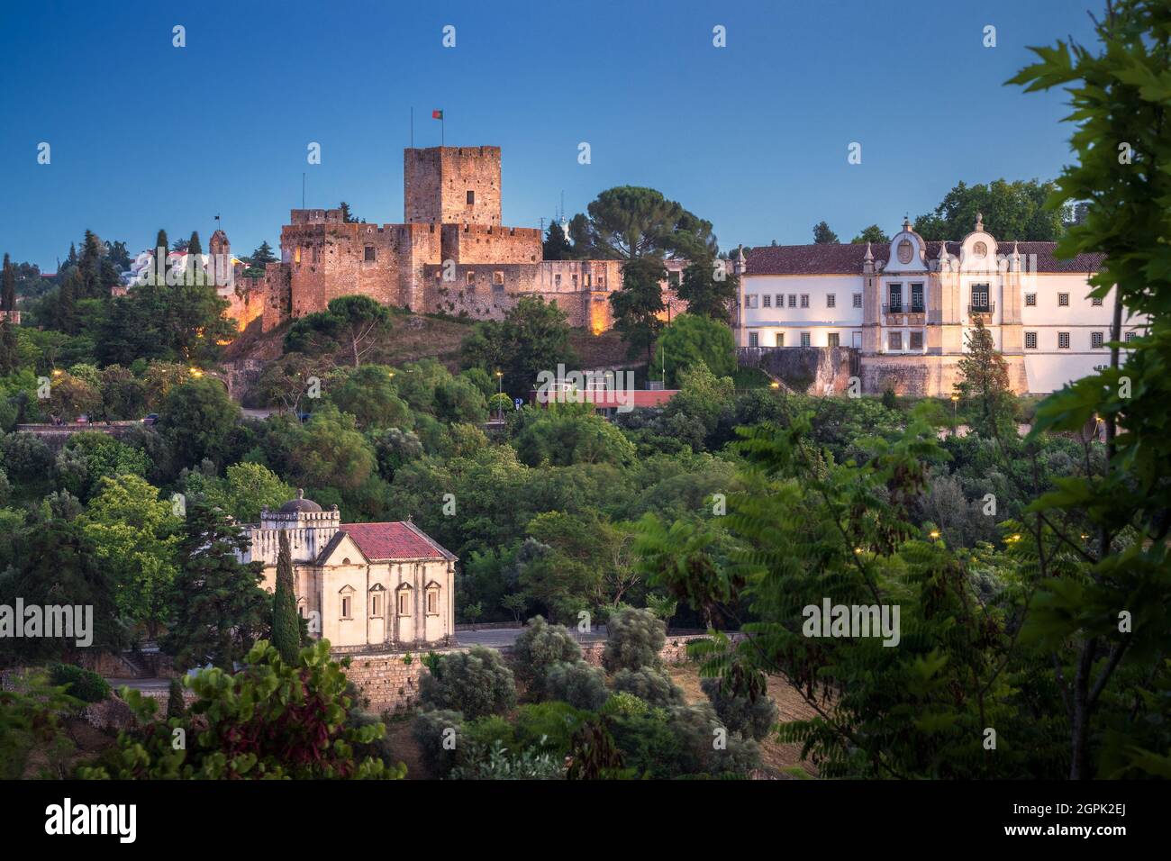 Blick in der Dämmerung auf die Burg von Tomar mit dem Kloster Christi auf der Seite und die Kapelle von Nossa Senhora da Conceição unten, in Tomar, Portugal. Stockfoto