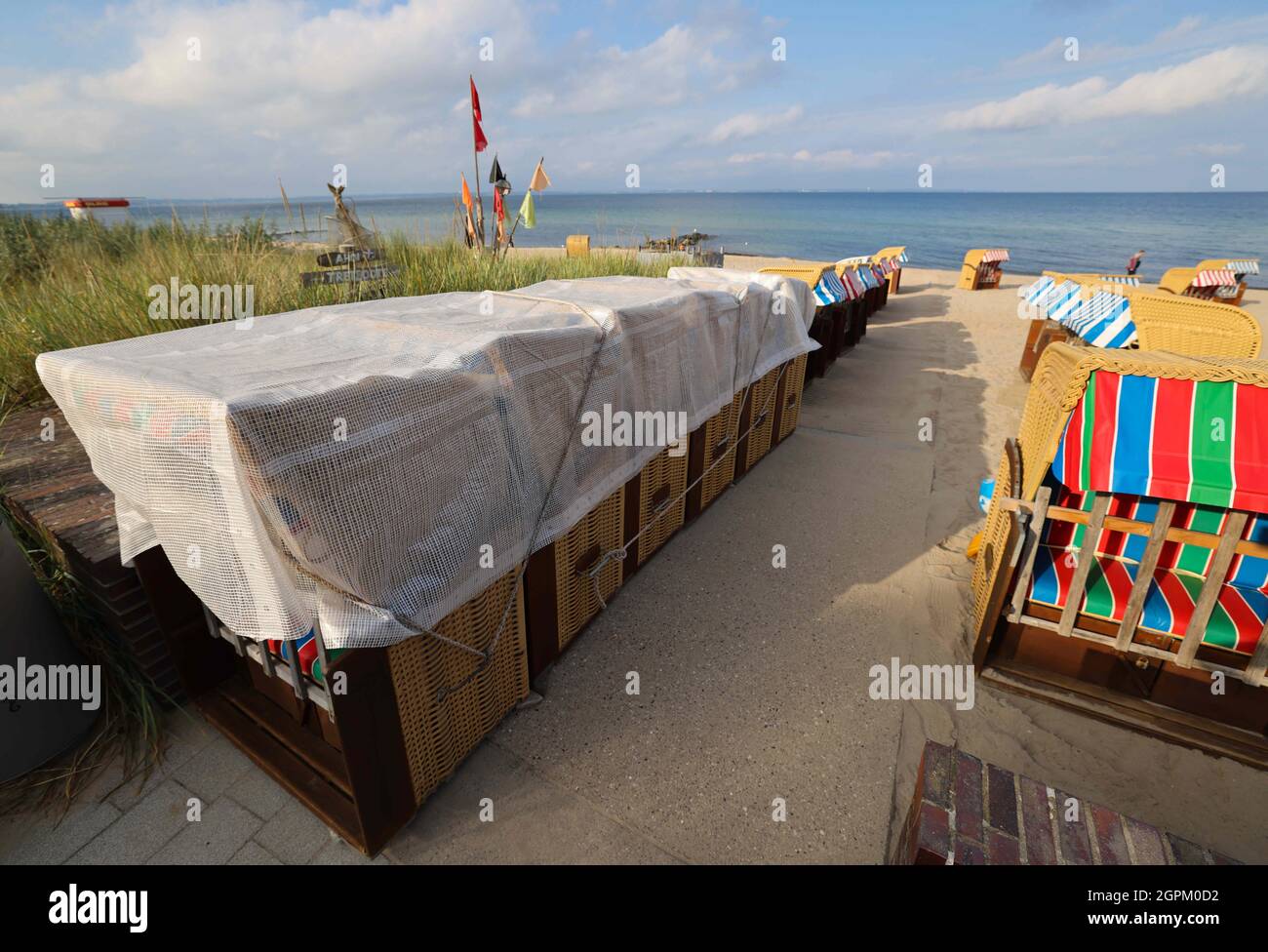 Timmendorfer Strand, Deutschland. September 2021. Liegen, teilweise bereits wetterfest verpackt, stehen an einem Strandzugang an der Promenade von Niendorf. Die Strandliegen-Saison an der Schleswig-holsteinischen Ostseeküste geht zu Ende. Quelle: Christian Charisius/dpa/Alamy Live News Stockfoto