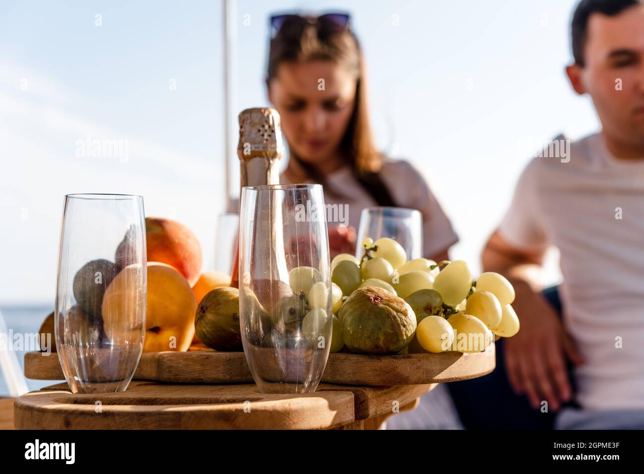 Obstschale und Flasche Champagner für ein romantisches Date auf einer Yacht Stockfoto