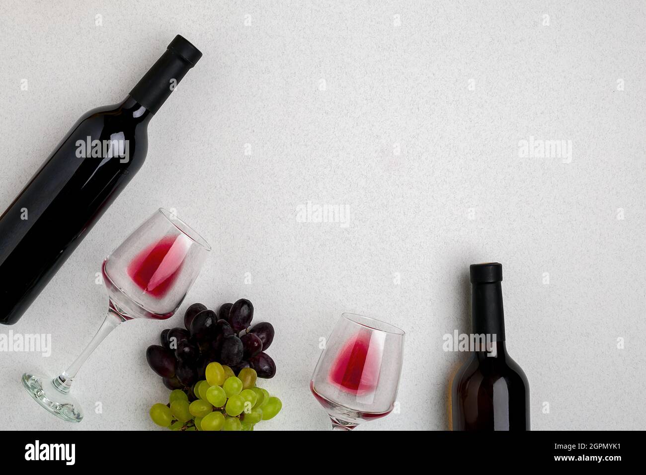 Gläser und Flaschen Rot- und Weißwein auf weißem Hintergrund von oben Stockfoto