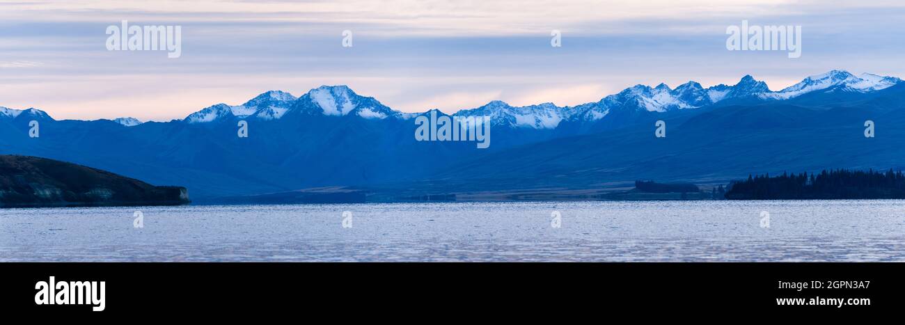 Panoramablick auf den Lake Tekapo mit den südlichen Alpen im Hintergrund bei Sonnenaufgang, Mackenzie Country, South Island. Stockfoto