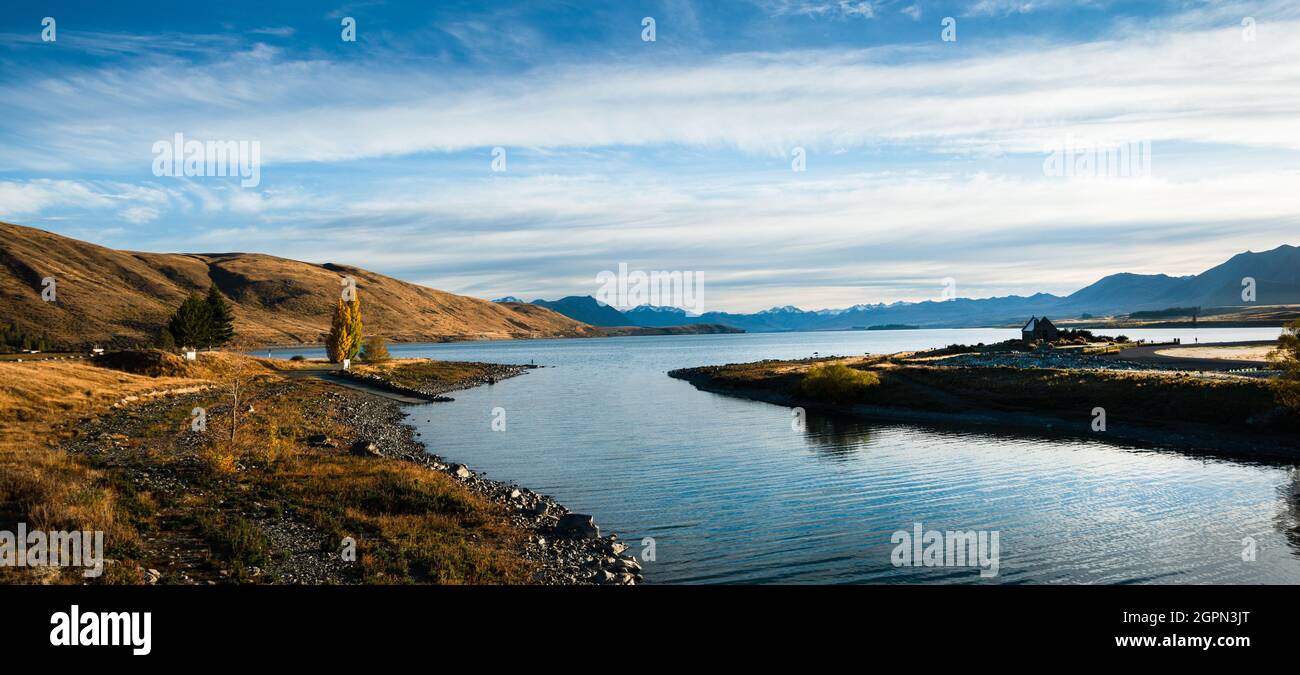 Panoramablick auf den Tekapo-See im Herbst mit der Kirche des Guten Hirten rechts und den südlichen Alpen im Hintergrund, Mackenzie-Land, Südinsel Stockfoto