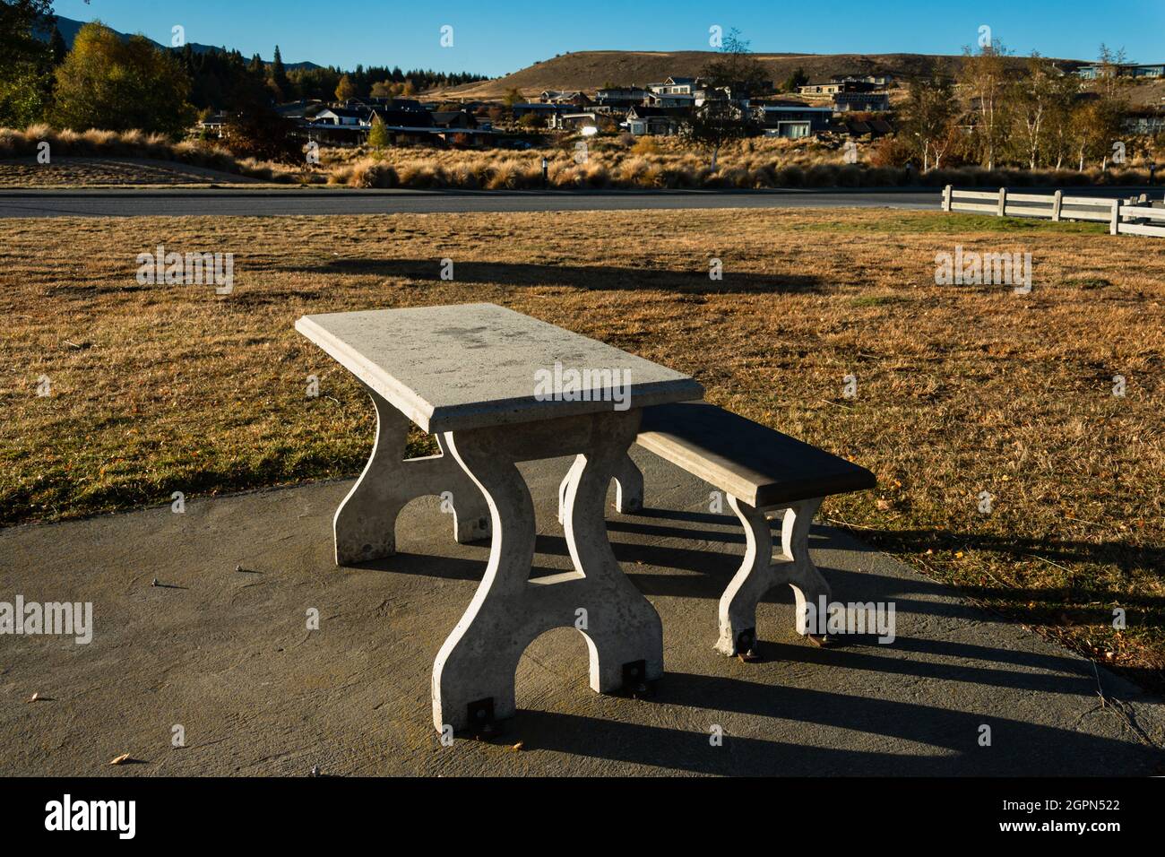 Picknicktisch und Bank aus Beton im Freien unter der Morgensonne im Herbst, Lake Tekapo, South Island. Stockfoto