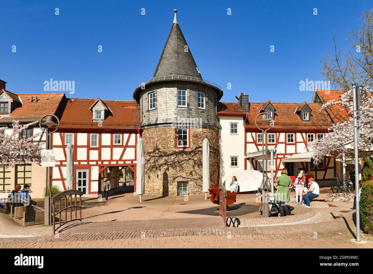 Hofheim, Deutschland - März 2021: Kleiner Stadtplatz mit Turm namens 'Untertor' und Teil der alten historischen Stadtmauer Stockfoto