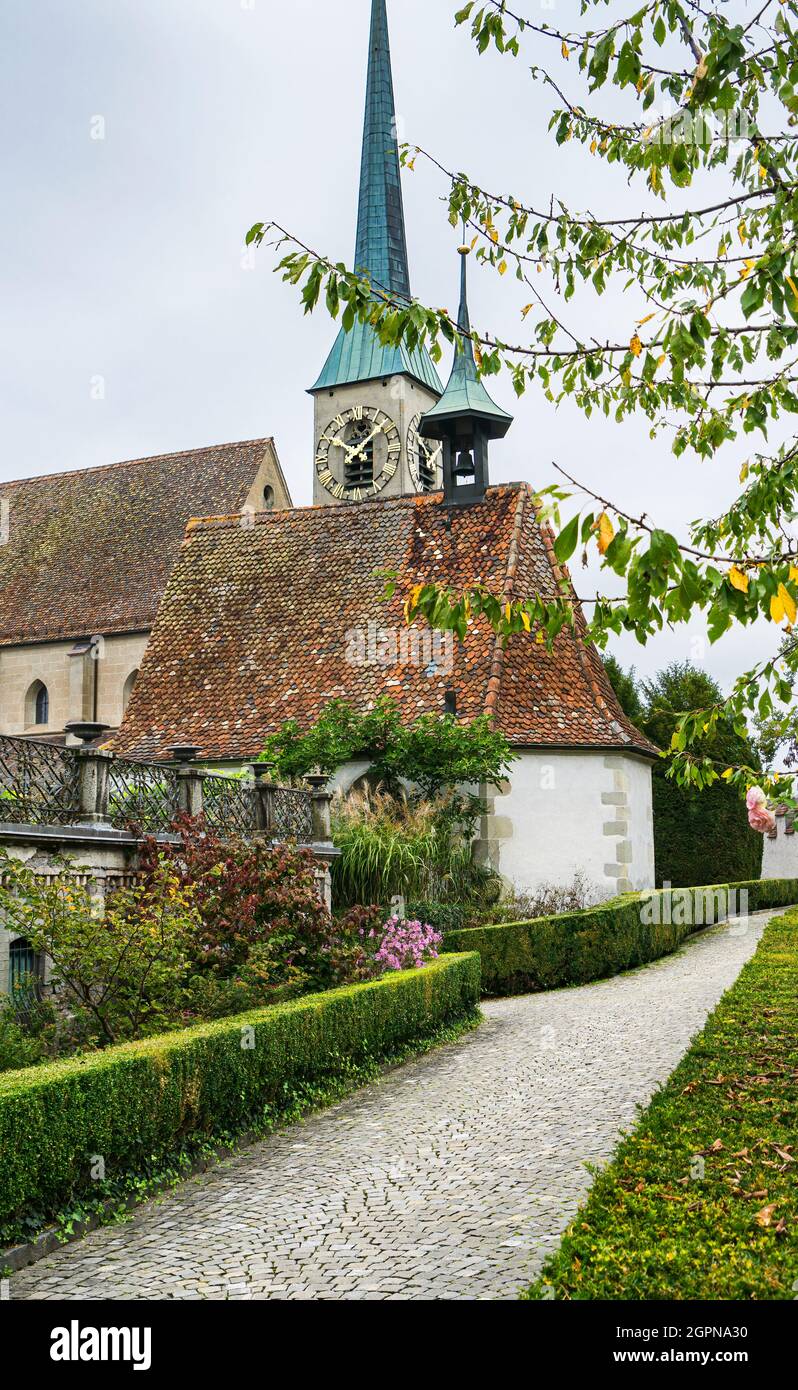 Blick auf die spätgotische Kirche St. Oswald in der Schweizer Stadt Zug und die Gärten im Freien. Stockfoto