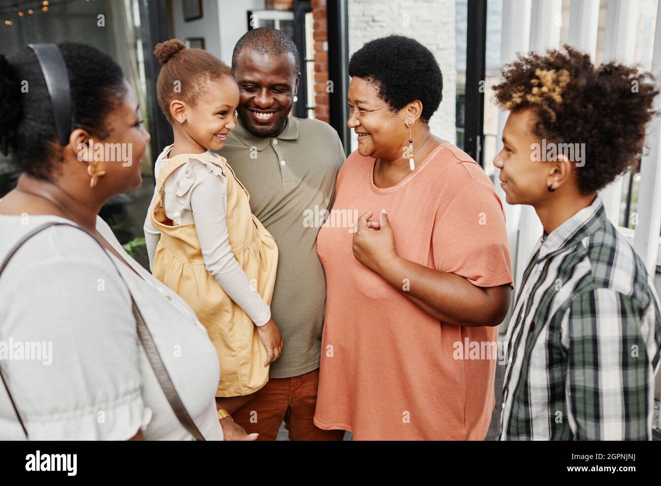 Porträt einer glücklichen Familie mit mehreren Generationen, die während des Treffens auf der Terrasse im Freien chattet Stockfoto