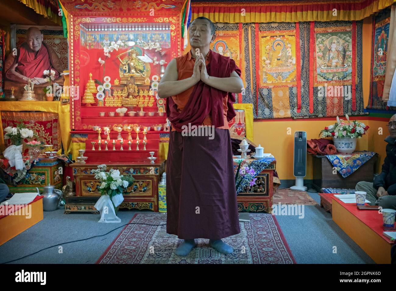 Ein Mönch aus einer Sherpa-Gemeinde hält Vorträge über seine Gemeinde in nepalesischer & tibetischer Sprache mit Handgesten während des Gebets. In Elmhurst, Queens, New York City. Stockfoto