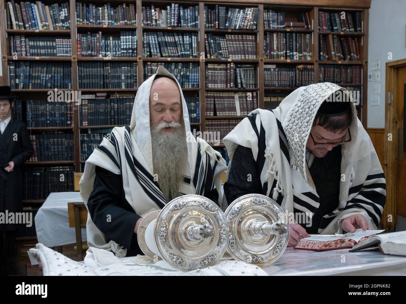 Ein orthodoxer jüdischer Mann rezitiert einen Segen, als er in einer kleinen Synagoge in Williamsburg, Brooklyn, NYC, bei einem Sukkos-Morgengottes zur Torah gerufen wurde. Stockfoto