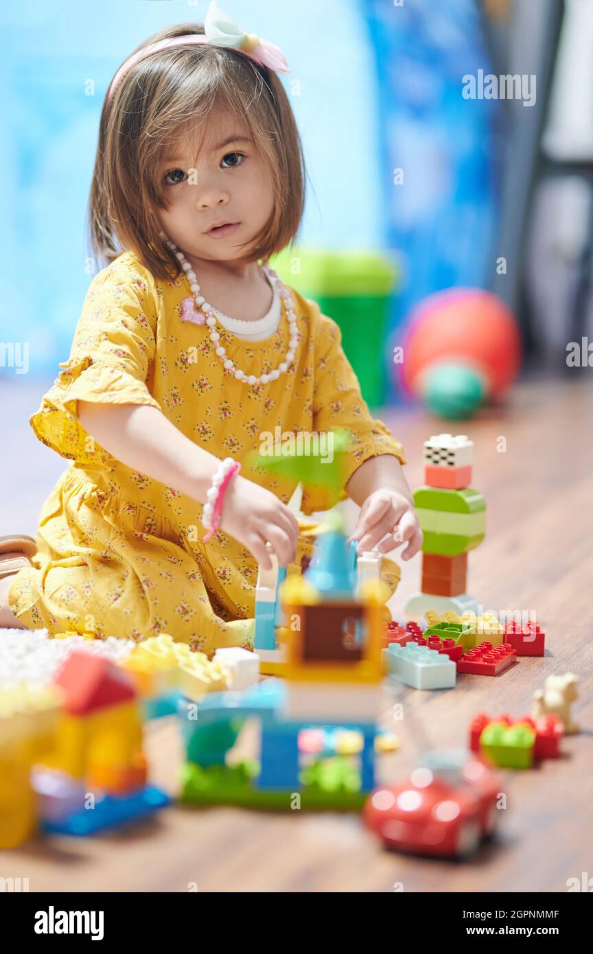 Hübsches Kind Mädchen spielt mit bunten Blöcken im Haus Stockfoto