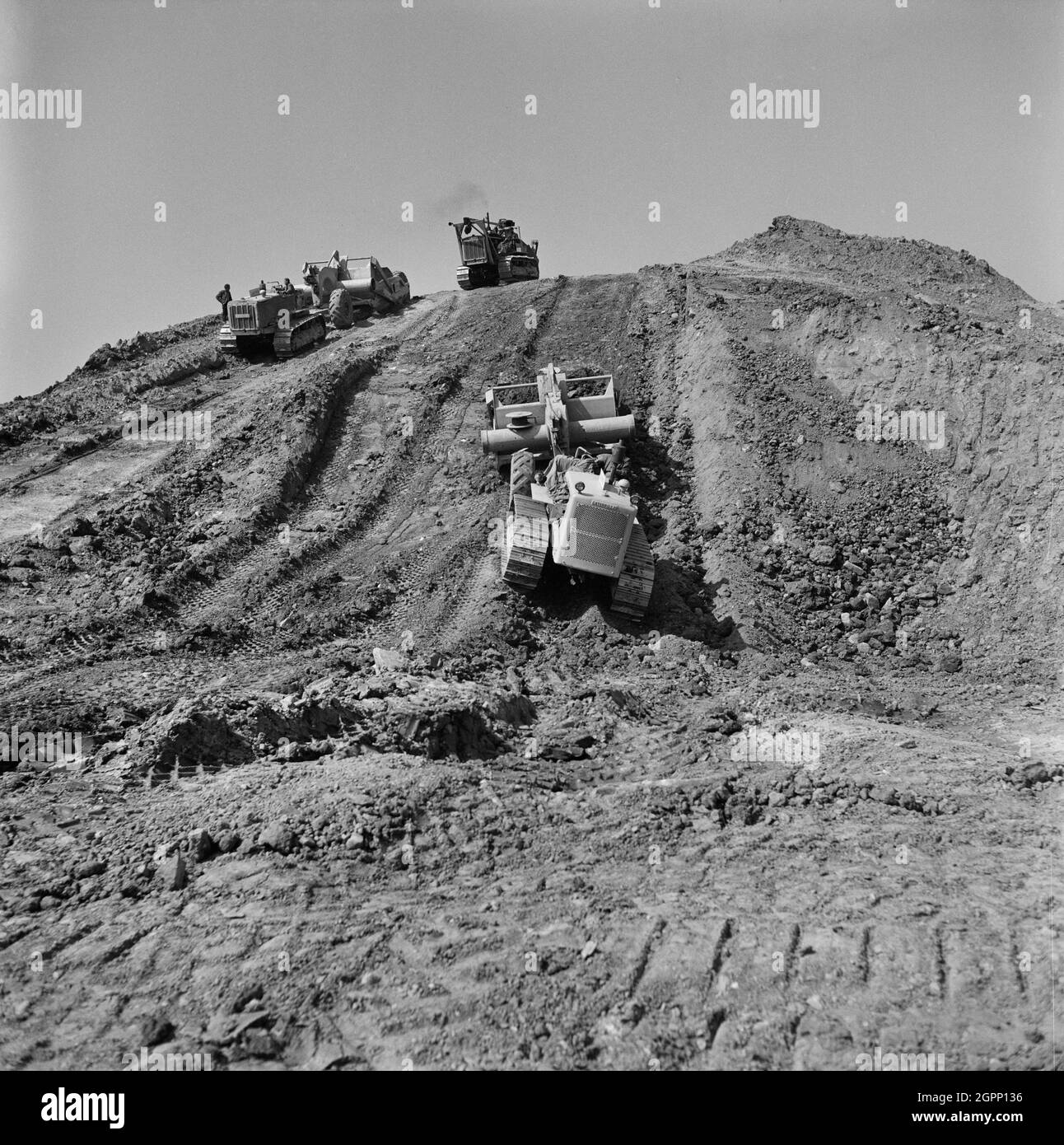 Ein Blick auf die Schaber, die während der Restaurierung des Golfplatzes Whitley Bay nach Abschluss des Tagebaus auf dem Gelände bei der Arbeit auf einem Schutthaufen arbeiten. John Laing und Son Ltd hatten 1942 mit dem Tagebau begonnen, um den Kriegsbedarf zu decken. Die Arbeiten wurden nach dem Krieg durch das Unternehmen erweitert und im Jahr 1948 fand der Tagebau auf dem Golfplatz auf dem Tagebaubetrieb in der Monkseaton-Gegend von Whitley Bay statt. 1953 wurde die Mine geschlossen und das Land zurückgewonnen. Stockfoto
