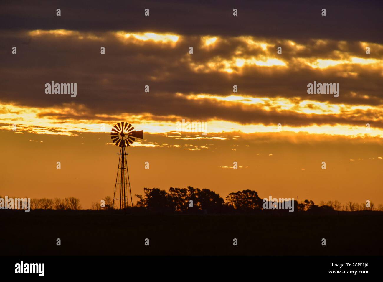 Windmühle bei Sonnenuntergang in der argentinischen Landschaft, Provinz Pampas, Patagonien, Argentinien. Stockfoto