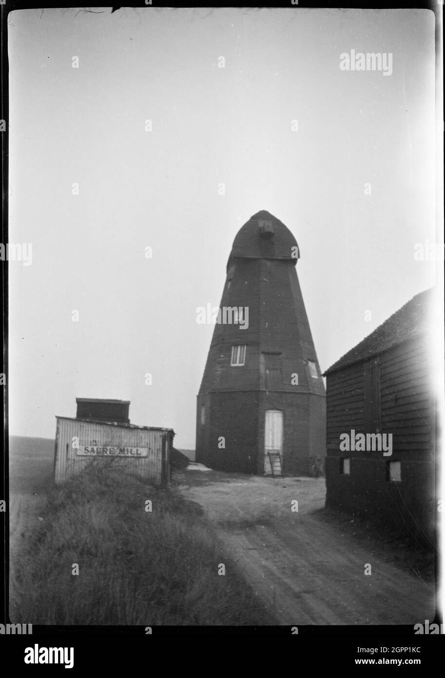 Sarre Windmill, Canterbury Road, Sarre, Thanet, Kent, 1929 Blick auf die Windmühle von Sarre, zeigt die Smokmühle ohne Segel. Die Windmühle von Sarre wurde 1820 für die Mahlung von Mais gebaut. Es hörte 1922 auf mit Wind zu arbeiten und wurde 1940 schließlich eingestellt, wurde aber später restauriert und 1992 wieder in Arbeit gebracht. Stockfoto