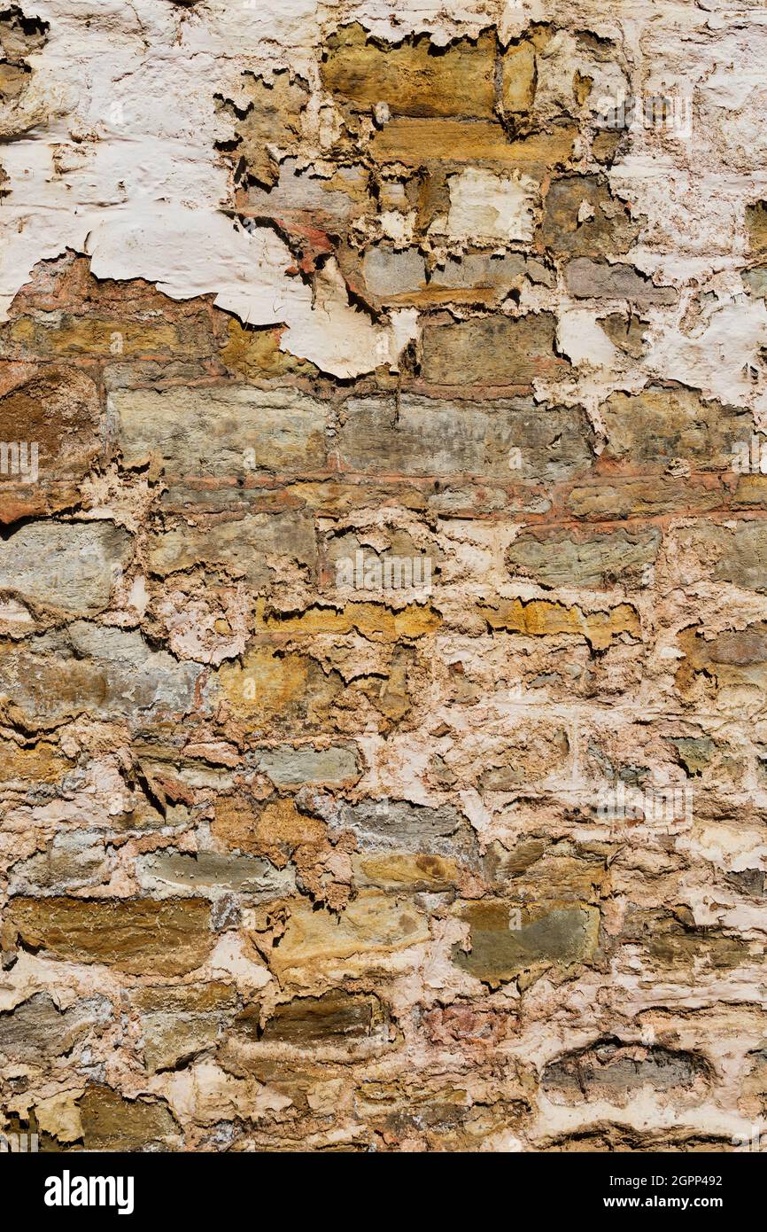 Flackende Farbe und Rendering mit altem Mauerwerk darunter. Durham, England Stockfoto
