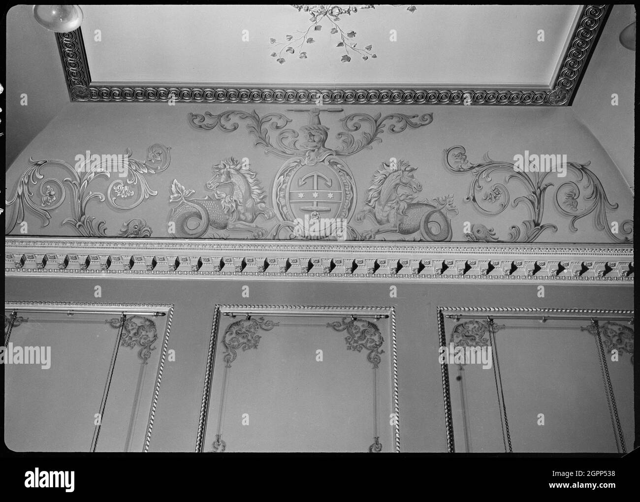 Trinity House, Trinity House Lane, City of Kingston upon Hull, 1941. Eine detaillierte Ansicht der Gipswandpaneele und der Koppeln im Gerichtssaal im Trinity House. Die Wände des Raumes haben erhöhte Gipsplatten und aufwendige Kovings mit Gipsschwänze und Gemälde von mythischen Tieren: Auf dem Bild sind zwei Hippocampi, oder Seepferde, auf beiden Seiten eines Emblems mit einem Anker. Der Gerichtssaal ist Teil des Trinity House, bestehend aus Büros und Häusern in einem polygonalen Plan um zwei Innenhöfe. Der Hauptblock stammt aus dem Jahr 1753 und das Guild House ist 1775, wobei die restlichen Gebäude in der gebaut wurden Stockfoto