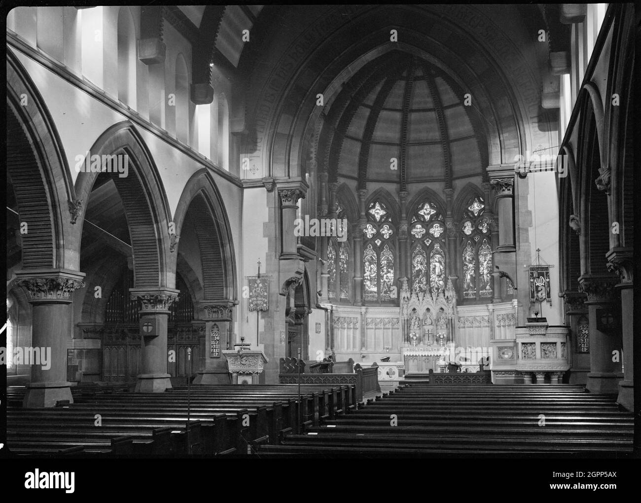 St Clement's Church, Chapeltown Road, Sheepscar, Leeds, 1942. Eine Innenansicht des Kirchenschiffs und des Apsidalkanals der St.-Clemens-Kirche, vom westlichen Ende aus gesehen und um 1976 abgerissen. Die Kirche wurde um 1868 nach Plänen von George Corston gebaut. Es verfügt über ein schiffiges Schiff aus fünf Buchten, eine Nord- und Südhalle, Sakristei, südöstlicher Turm und einen Apsidal-Chor. Die Arkaden hatten breite Spitzbögen auf eckigen zylindrischen Pfeilern, und oben waren paarige runde klerestorische Fenster. Der Kanzelbogen hat kurze Säulen mit korinthischen Kapitellen und einen spitzen Bogen mit zwei Ordnungen. Die Apsis hatte möglicherweise acht b Stockfoto