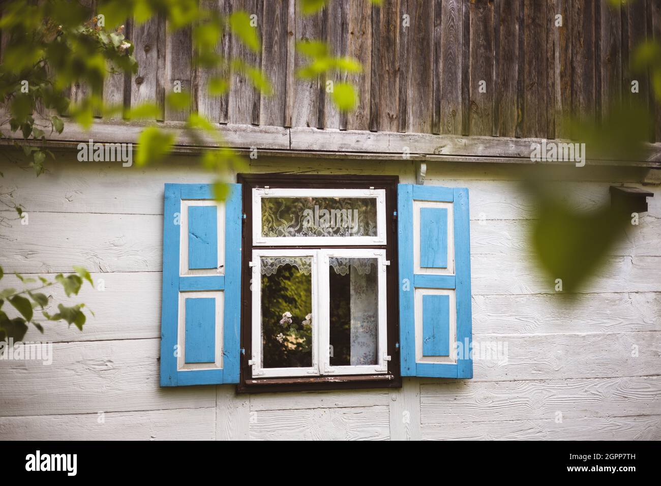 Fenster mit Fensterläden im traditionellen Holzhaus, Polen Stockfoto