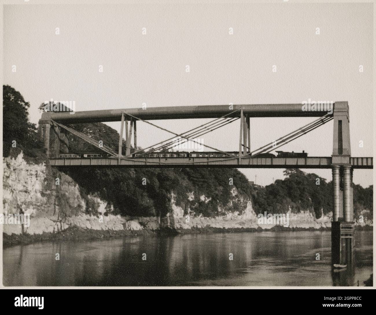 Chepstow Rail Bridge, Tidenham, Forest of Dean, Gloucestershire, 1951. Der östliche Teil der Chepstow Rail Bridge, von Nordwesten aus gesehen, mit einem Zug, der über die Brücke fährt. Die Chepstow Rail Bridge wurde von Isambard Kingdom Brunel entworfen und 1852 fertiggestellt. Es war auch bekannt als die 'Great Tubular Bridge'. Die Brücke wurde durch eine neue Brücke ersetzt, die 1962 gebaut wurde, obwohl die Stahlrohrstützen der ursprünglichen Brücke erhalten geblieben sind. Stockfoto