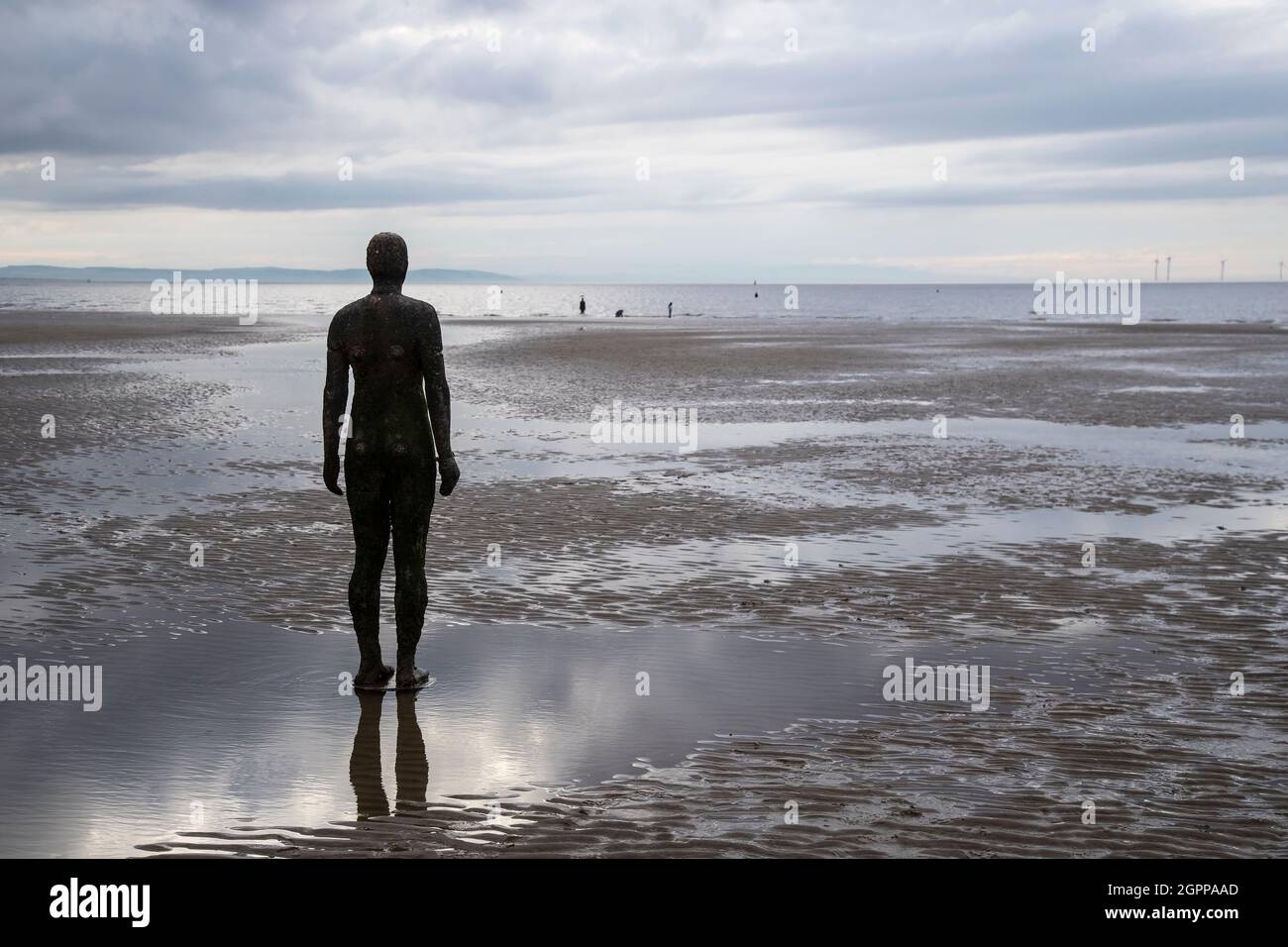 Eine von hundert gusseisernen Figuren, die Antony Gormley mit dem Titel „Another Place“ am Crosby Beach, Merseyside, Großbritannien, modelliert hat Stockfoto