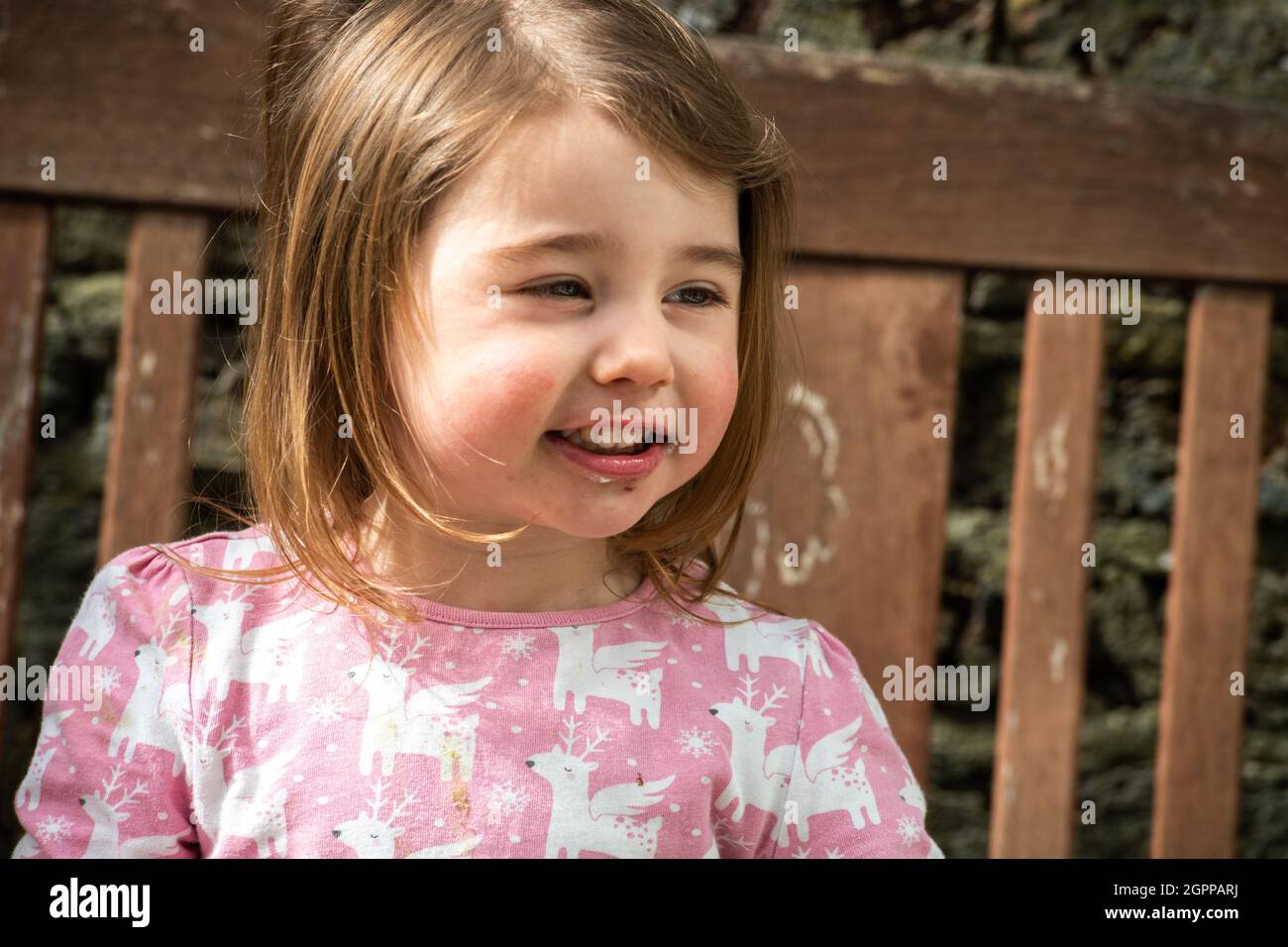 Großbritannien, Porträt eines lächelnden Mädchens (2-3) im Freien Stockfoto