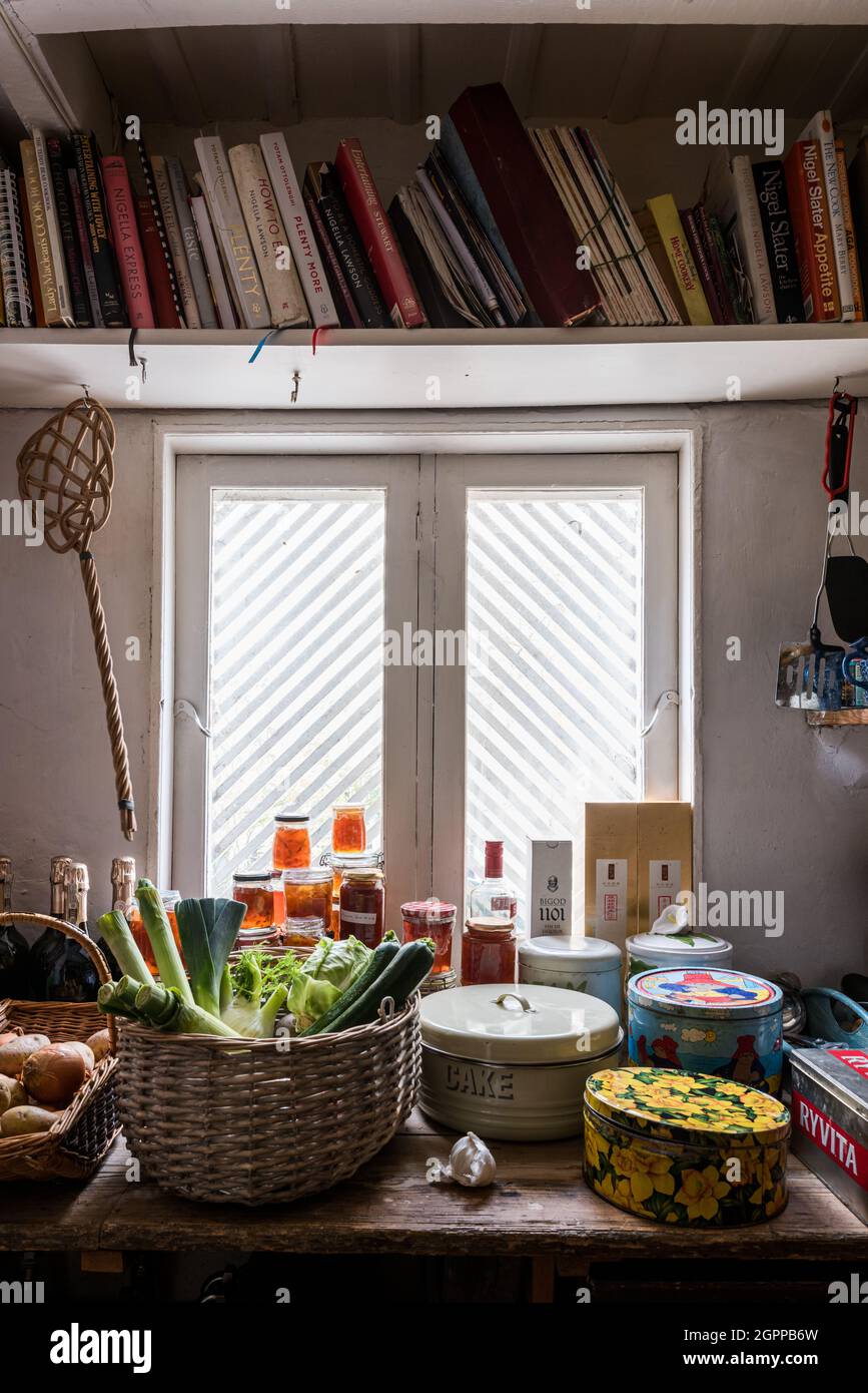 Kochbücher und Marmelade mit geätztem Glasfenster in der Speisekammer von Suffolk Cottage. Stockfoto