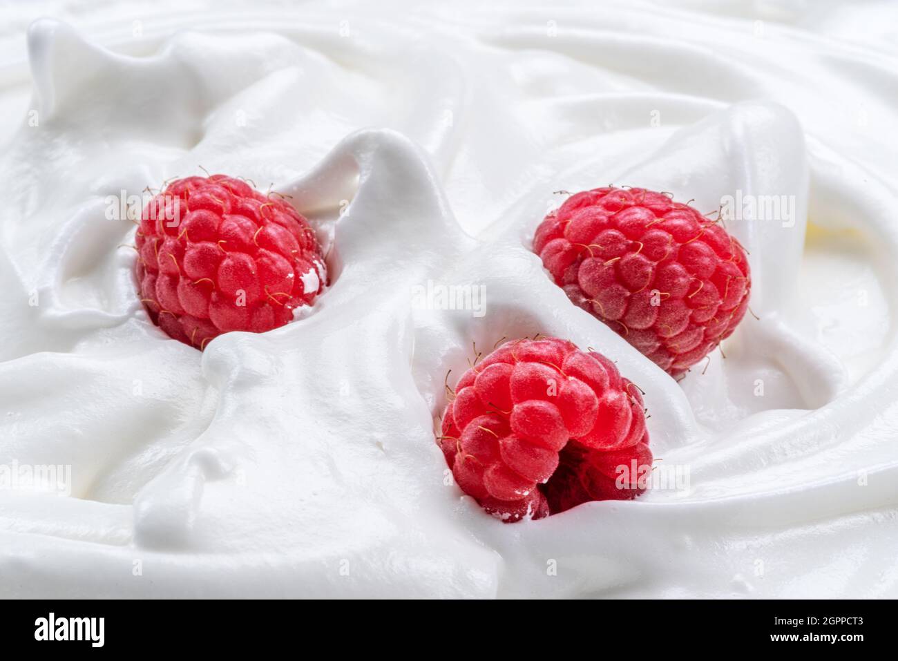 Frische Himbeeren im Joghurt oder in der Creme. Draufsicht. Stockfoto