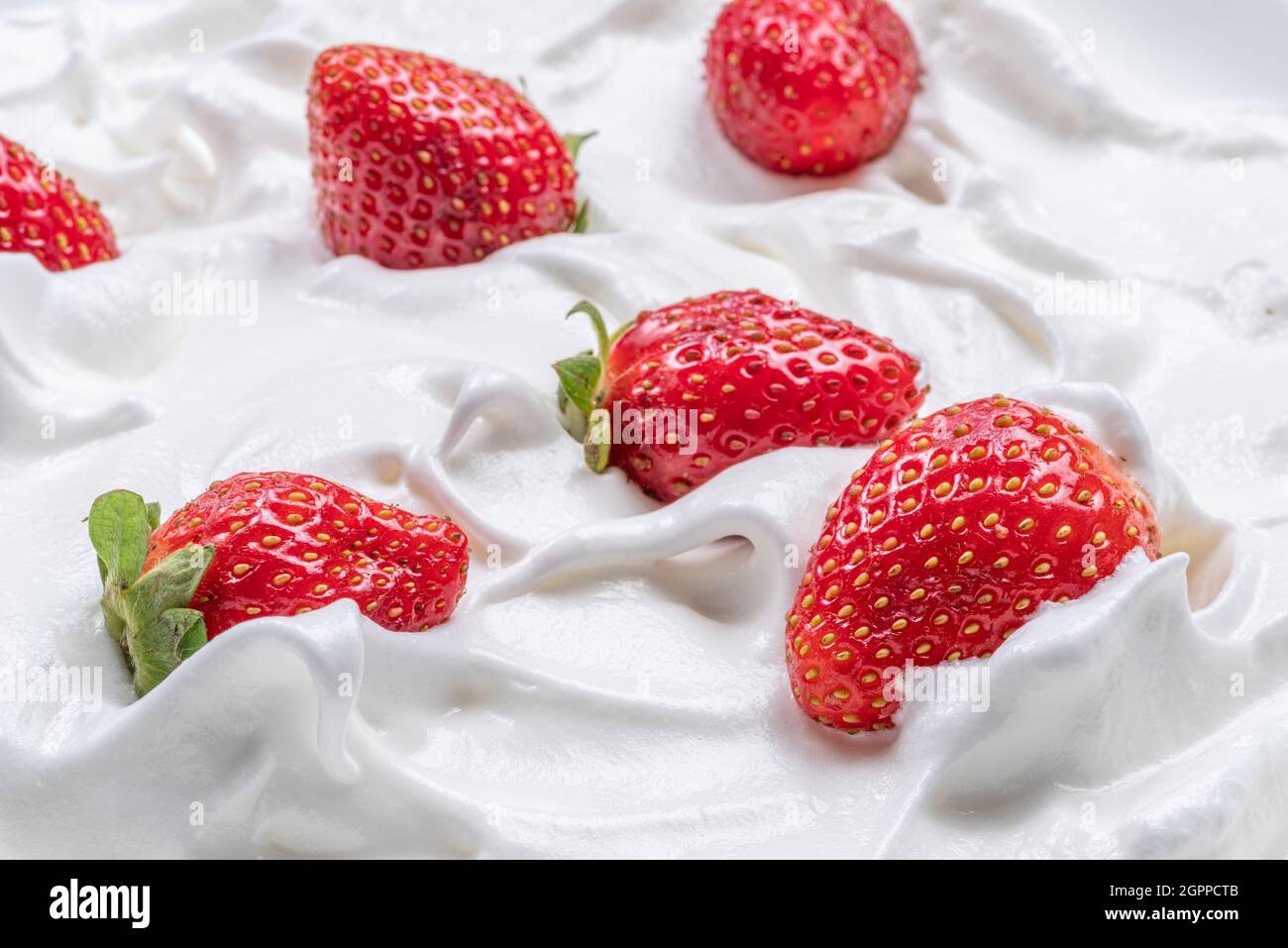Frische Erdbeeren im Joghurt oder in der Creme. Draufsicht. Stockfoto